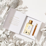 Silky Woods Holiday Gift Set with 100ml gold bottle and 10ml travel spray in open white box surrounded by white dried flowers